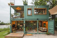 a house made out of shipping containers with lots of windows