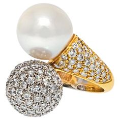 Vintage Bypass Pave Diamond & South Sea White Pearl Gold Ring. Vintage Bypass Diamond and South Sea Button White Pearl Ring is set in gold mounting. The Bypass design features a Pave set Diamond Ball with 4.50 cts. of Round Brilliant and South Sea White Pearl measuring at 12mm. Celebratory and chic, this Vintage piece from the 1960s symbolizes the decade as the height of mod fashion. CARAT WEIGHT: 4.50cts (approx.) SIZE: 7.5 MATERIAL: 18K GOLD WEIGHT: 13.6gr Fancy Pink Diamond Ring, Diamond And Pearl Ring, Cocktail Ring Designs, Pearl Cocktail Ring, Diamond Ball, White Pearl Ring, Milano Italy, Pearl And Diamond Ring, Gold Cocktail Ring