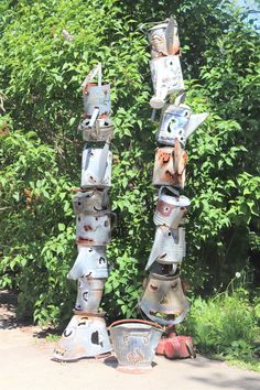 several metal objects are stacked on top of each other in front of trees and bushes