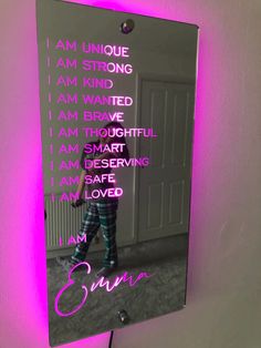 a mirror with the words i am unique on it and a pink light behind it