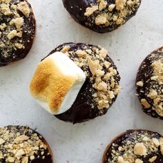 chocolate covered donuts with crumbs and marshmallow on top