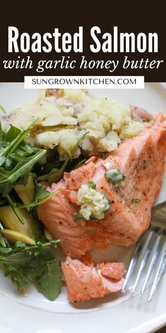 roasted salmon with garlic honey butter and spinach on a white plate next to a fork