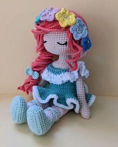 a crocheted doll sitting on top of a white table next to a wall