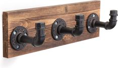 a wooden coat rack with three pipe holders