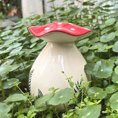 a vase sitting in the middle of some plants