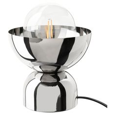 a shiny metal table lamp with two lights on it's base and a black cord running through the bulb