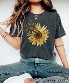 "Sunflower And Butterfly T-Shirt, Comfort Colors Shirt, Boho Retro Shirt For Women, Botanical Floral, Gardening Shirt, Oversized Tee PLEASE SIZE UP FOR AN OVERSIZED FIT If you are looking for an oversized \"T-shirt Dress\" look, we recommend sizing up 2 sizes. Comfort Colors introduces its garment-dyed t-shirt; a fully customizable tee made 100% with ring-spun cotton.  The soft-washed, garment-dyed fabric brings extra coziness to your wardrobe while the relaxed fit makes it an excellent daily choice. The double-needle stitching throughout the tee makes it highly durable while the lack of side-seams helps the shirt retain its tubular shape. .: 100% ring-spun cotton .: Medium fabric (6.1 oz/yd² (206.8 g/m .: Relaxed fit .: Sewn-in twill label" Yellow T-shirt With Sunflower Design For Spring, Summer Casual T-shirt With Sunflower Print, Black T-shirt With Sunflower Print For Spring, Yellow Short Sleeve T-shirt With Sunflower Design, Casual Cotton T-shirt With Sunflower Print, Yellow Short Sleeve Tops With Sunflower Design, Yellow Shirt With Sunflower Print For Summer, Yellow Sunflower Print Short Sleeve Top, Short Sleeve Yellow Tops With Sunflower Design