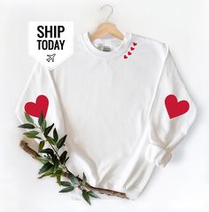 a white shirt with red hearts on it and a sticker that says ship today