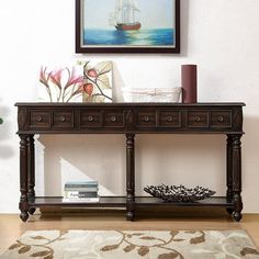 a wooden table with two drawers and a painting on the wall in front of it