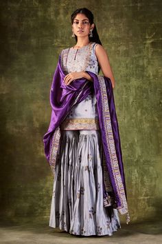 Grey printed kurta highlighted with dori and zardozi work. Paired with printed gharara and purple dupatta.
Component: 3
Pattern: Printed,Embroidered
Type Of Work: Dori and Zardozi Work
Neckline: Round
Sleeve Type: Sleeveless
Fabric: Chanderi Silk, Organza Silk
Color: Grey
Other Details: 
Purple dupatta
Tiered sharara
Embroidered bodice
Occasion: Wedding - Aza Fashions Gharara Designs, Punit Balana, Pink Anarkali, Kurta Sharara Set, Kurta Sharara, Anarkali Dress Pattern, Indian Wedding Photos, Silk Outfit, Printed Kurti