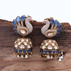 Our breathtaking Peacock Motif Statement Earring, adorned with fine quality Moissanite and a captivating Blue stone that exudes elegance and sophistication. Meticulously crafted in 925 Silver, this earring mirrors the authenticity of Indian Polki style, accentuated by high carat gold-plated silver. The omega hook and push-back closure ensure a secure and robust stud, making it an exquisite choice for weddings or evening soirees. Elevate your festive ensemble or gift this remarkable Diwali present to yourself or a loved one. Gross Weight: 43.78 gms Dimensions: 52 x 25mm Explore more exquisite pieces at our [Etsy Shop](https://www.etsy.com/in-en/shop/TempusGems). Explore more in our shop: [TempusGems](https://www.etsy.com/in-en/shop/TempusGems) Packaging and Shipping We take great care to en Elegant Chandbalis With Peacock Design For Diwali, Traditional Sterling Silver Diamond Earrings, Elegant Peacock Earrings For Wedding, Elegant Peacock Colored Earrings For Wedding, Diamond Earrings With Latkans For Diwali, Silver Diamond Earrings With Meenakari, Elegant Kundan Jhumkas With Peacock Design, Traditional Cubic Zirconia Earrings For Diwali, Elegant Silver Chandbalis With Peacock Design