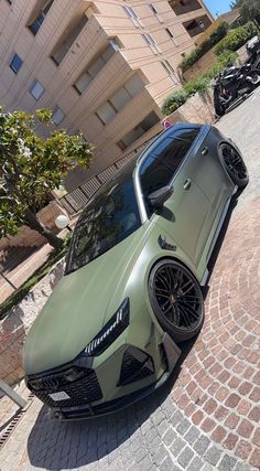 a green sports car parked in front of a building