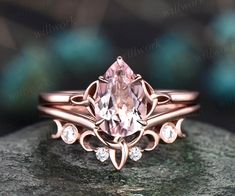 a pink diamond ring sitting on top of a rock with diamonds in the band and an intricate design around it