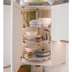 an open cabinet in a kitchen filled with dishes