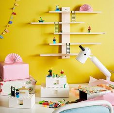 a room with yellow walls and various items on the table, including a desk lamp