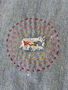 an embroidered piece of clothing with red, yellow and blue sprinkles on it