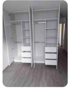 an empty room with white closets and shelves in the middle, all painted white