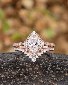 an engagement ring with a pear shaped diamond in the center on top of a rock