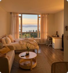 a living room filled with furniture and a large window covered in curtains next to a bed