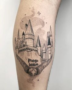 a tattoo on the leg of a man with a hogwarts castle in it