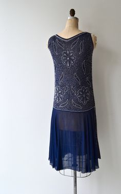 "Vintage 1920s deep blue silk dress with clear and grey bugle beading in floral pattern, classic jazz age unfitted cut with unadorned fluttery skirt panels on each side as well as the back. No closures, slips on easily over the head. [m e a s u r e m e n t s] fits like: small/medium bust: 34-36\" waist: best fit up to 31\" hip: 38\" length: 42\" [i n f o] brand/maker: n/a fabric content: silk condition: excellent (some missing beads on back at the collar, see photo) to ensure a good fit, please 1920s Embellished Sleeveless Flapper Dress, 1920s Embellished Summer Dresses, 1920s Style Embellished Summer Dresses, Embellished 1920s Style Summer Dresses, 1920s Style Summer Flapper Dress, Fitted Blue Flapper Dress, Fitted Blue Flapper Dress For Summer, Blue Fitted Sleeveless Flapper Dress, 20s Flapper Dress