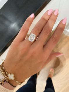 a woman's hand with pink manicures and a diamond ring