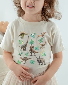 Dinosaur Shirt for Kids Gender Neutral Kids Clothes TRex Shirt BOHO Dino Tshirt Girl Dinosaur Shirt Boy Dinosaur T Shirt Matching Mom Shirts A trendy cottagecore dino tee!  Sure to be a new favorite conversation starter for your reptile lover!  Want to match? Check our shop for baby and adult sizes in this print!  * Q U I C K * F A C T S * * T E E S * ✺ 100% preshrunk cotton ✺ Heather colors are 52% combed and ring-spun cotton, 48% polyester ✺ Athletic Heather is 90% combed and ring-spun cotton, 10% polyester ✺ Inside out and wash and dry on cool for best results.  Do not iron decoration. ✺ printed using DTG Direct to Garment printing.  ✺ Colors may vary due to computer monitors and printing inks. ✺ While we offer several shirt colors some may have a better contrast with the design. Keep t Casual Green Dinosaur Print Tops, Casual Green Tops With Dinosaur Print, Green Cotton Dinosaur Print Tops, Green Cotton Tops With Dinosaur Print, Unisex Dinosaur Print Crew Neck Top, Dinosaur Print Crew Neck Graphic Tee, Dinosaur Print Graphic Tee With Crew Neck, Casual Unisex Dinosaur Print Tops, Summer Dinosaur Print Short Sleeve Tops