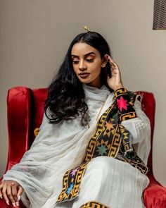 This Shimena Ethiopian traditional dress is a true masterpiece that embodies timeless elegance and sophistication. The dress is made with high-quality Menen fabric, which adds a touch of luxury and refinement to the overall design. The dress features a wide Tilf design that adds a traditional charm to the modern silhouette. The dress is designed to fit comfortably and flatteringly, with a fitted bodice and a full skirt that flows beautifully as you move. The dress is complemented by carefully se Traditional Drape Dresses For Eid Rituals, Traditional Cutdana Dresses For Ceremonies, Transitional Traditional Dress With Cutdana, Traditional Festive Handloom Dress, Traditional Drape Kurta For Rituals, Traditional Ceremonial Saree Dress, Traditional Dress With Cutdana For Festivals, Traditional Chanderi Handloom Dress, Traditional Handloom Dresses For Festivals