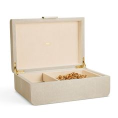 an open box with gold jewelry inside on a white background and the lid is closed