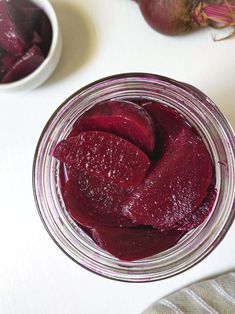 a jar filled with beets sitting on top of a table next to other items