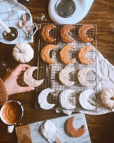 someone is decorating pumpkins with icing on a cooling rack and other decorations