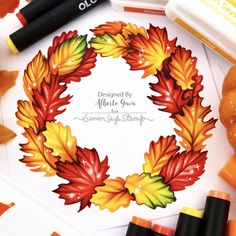 an autumn wreath surrounded by crayons and markers