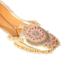 Bringing class to your wardrobe with our beautifully handcrafted 'golden Crown' juttis. Glossy silver based adorned with palmette like motif that is embroidered with gotapatti and silver dabka work. We added bunches of ivory beads to give it a fuller look. Asymmetrical neckline adds an extra glamour to the whole jutti. You can pair these up with an embroidered lehenga or saaree in contrasting color for a party or festive look! Color: Gold Fabric: Faux Leather Upper- Silver faux Leather - leather Festive Gold Traditional Wear With Embroidery, Gold Traditional Wear With Gold Embroidery For Festive Occasions, Festive Gold Traditional Wear With Gold Embroidery, Festive Traditional Wear With Gold Embroidery For Festivals, Embellished Silver Traditional Wear, Gold Traditional Wear With Handwork, Silver Embellished Traditional Wear, Silver Embroidered Traditional Wear For Festive Occasions, Silver Designer Traditional Wear