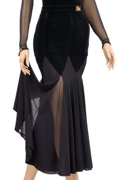 a mannequin wearing a black dress with sheer sleeves and an asymmetrical skirt