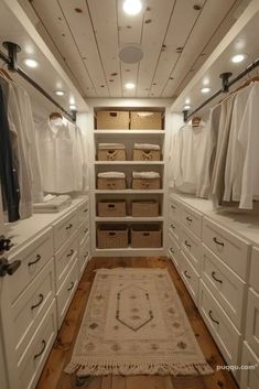 a walk in closet filled with lots of white cabinets and linens on top of drawers