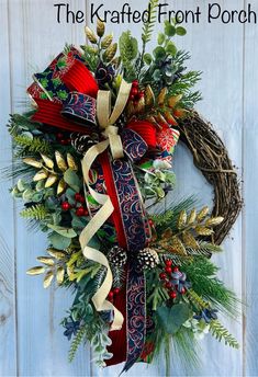 a christmas wreath with red, white and blue ribbons hanging on a wooden door that says the kraffe front porch