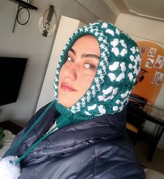 a woman wearing a green and white crocheted hat