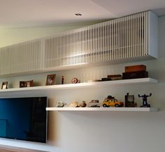 a flat screen tv sitting on top of a white shelf