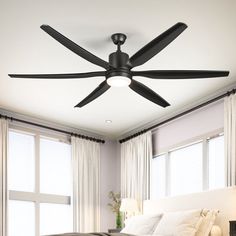 a bed room with a neatly made bed and a ceiling fan in the middle of it