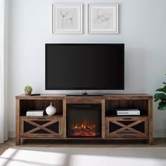 a flat screen tv sitting on top of a wooden entertainment center next to a fire place