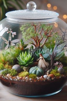 a glass bowl filled with plants and rocks