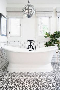 a bathroom with black and white tile flooring, a claw foot bathtub in the middle