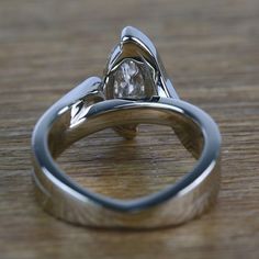 two wedding rings sitting on top of a wooden table with a diamond in the middle