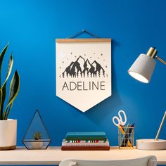 a blue wall with a sign that says adeline on it and some office supplies