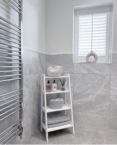 a white shelf in a bathroom next to a radiator