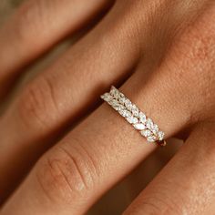 a woman's hand with a diamond ring on top of her finger and the band is