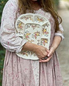 a woman in a pink dress holding a white plate