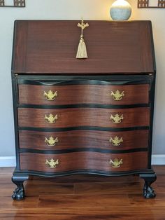 an antique chest of drawers with brass hardware