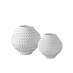 two white vases sitting next to each other on a white background, one is empty