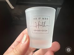 a person holding up a shot glass with the words mr and mrs on it